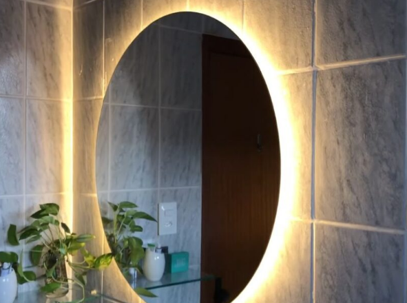 Espelho redondo com iluminação de LED integrada instalado em banheiro