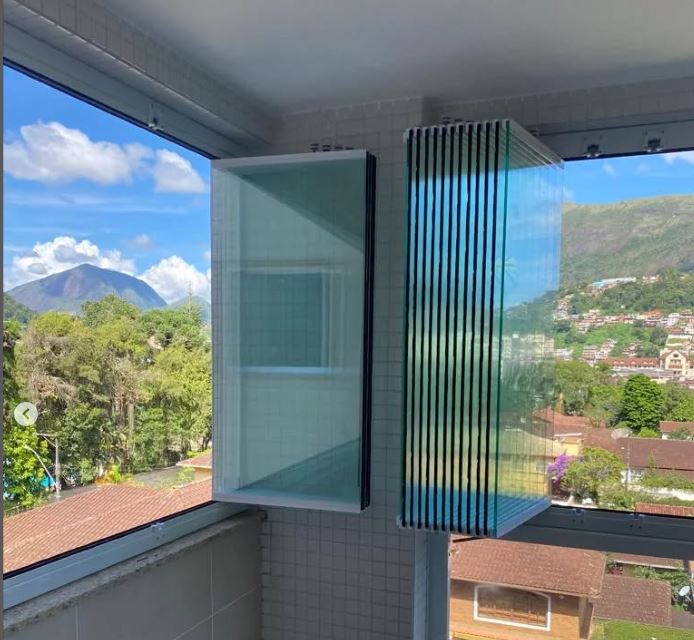 Janela cortina de vidro dobrada, abrindo o vão de canto em apartamento de Porto Alegre