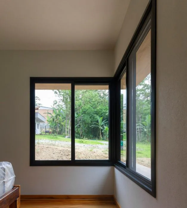 Janela de vidro aberta com vista para jardim